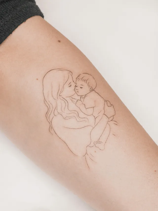 Tatuagem fine line de mãe com bebê, por Julie